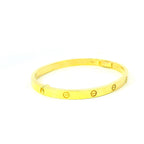 solid gold bangle with circle pattern. screw gold bangle. gold bangle for women