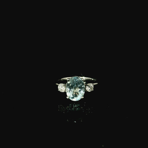 large oval cut aquamarine stone with two surrounding diamonds 