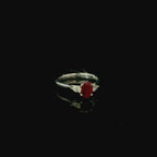platinum ring with oval cut mid red ruby gemstone. pear cut diamonds 