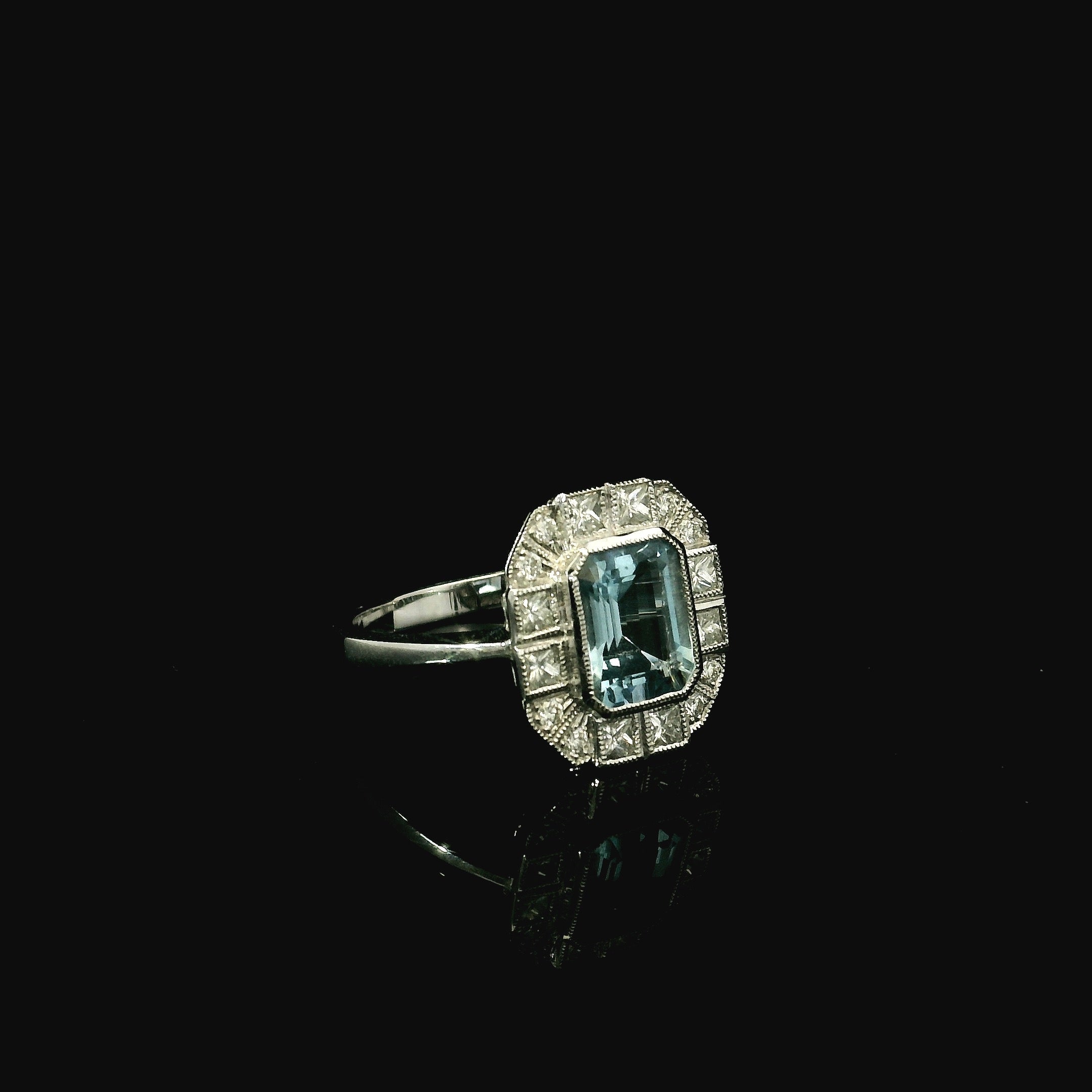 rounded ring with central aquamarine stone with surrounding princess cut diamonds in kent 