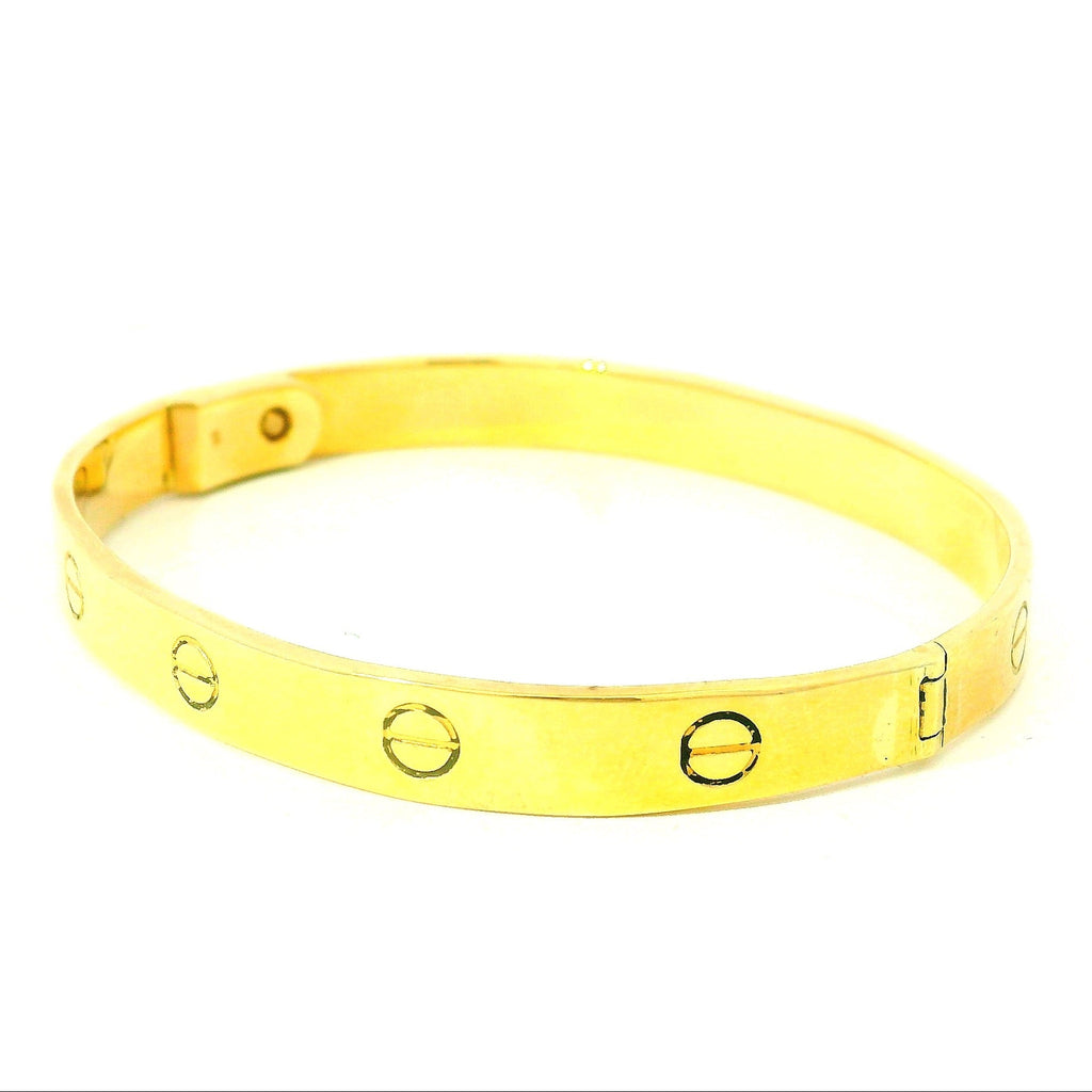 solid gold bangle with screw design. solid gold bracelet with oval marks. christening bracelet gold