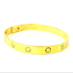 solid gold bangle with screw design. solid gold bracelet with oval marks. christening bracelet gold