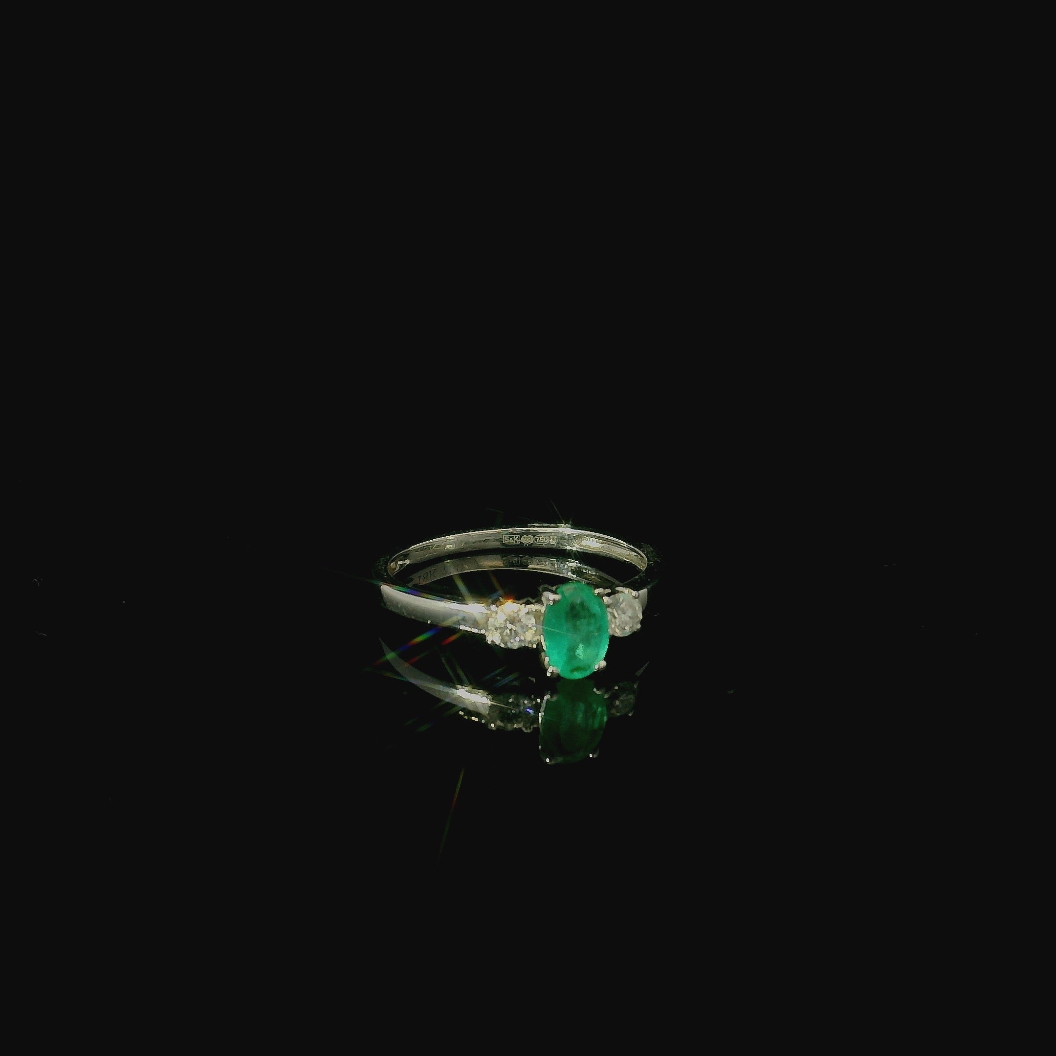18ct white gold ring with oval cut emerald stone with two diamonds. simple sleek diamond ring. modern rings for women. birthday gift for women