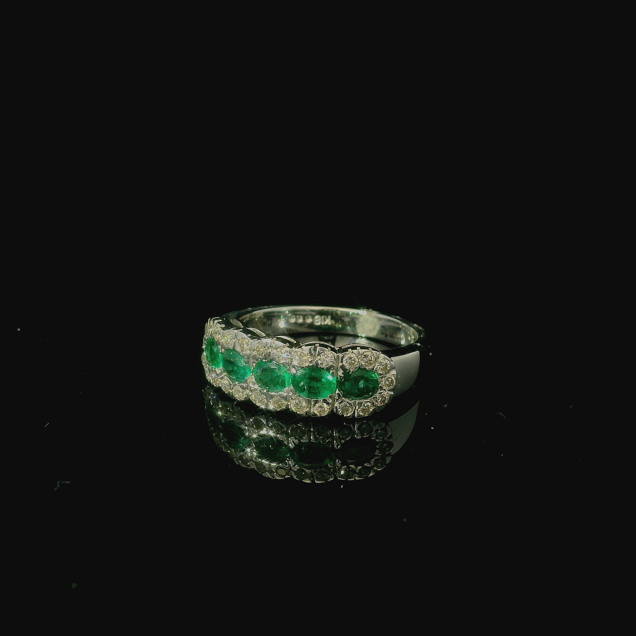 bright white gold ring with emerald gemstones and diamonds. rings to symbolise love, rebirth, fertility and wisdom.