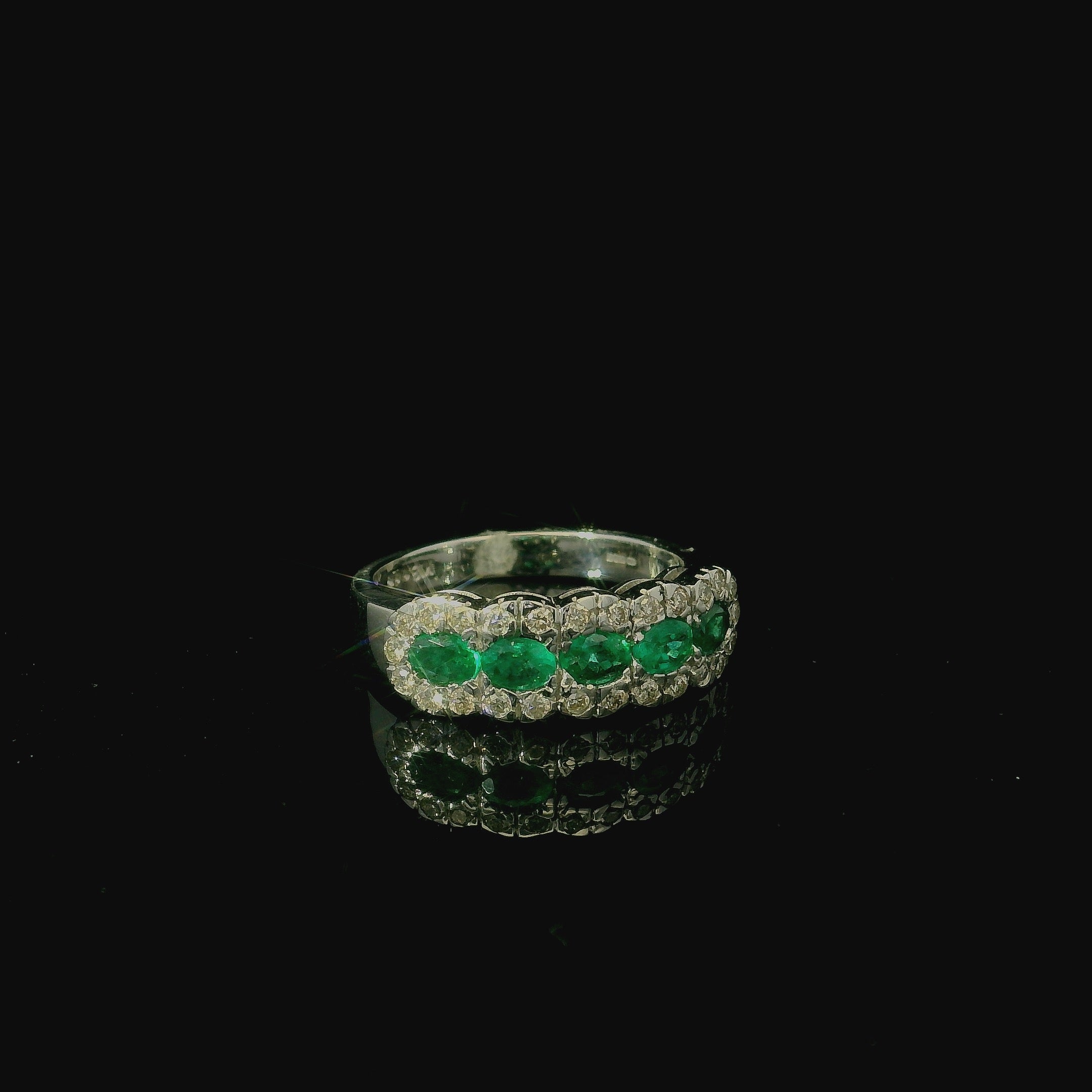 white gold ring with bright green emeralds and diamonds. luxury bold statement ring for women.